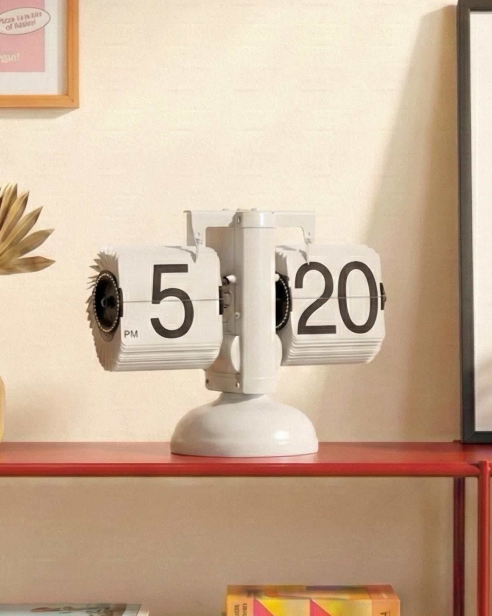 Side view of white gear-operated flip clock showing the internal mechanism and sleek industrial design.