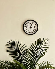 Aesthetic black and white doodle clock mounted on a neutral beige wall, perfect for living room or office decor.
