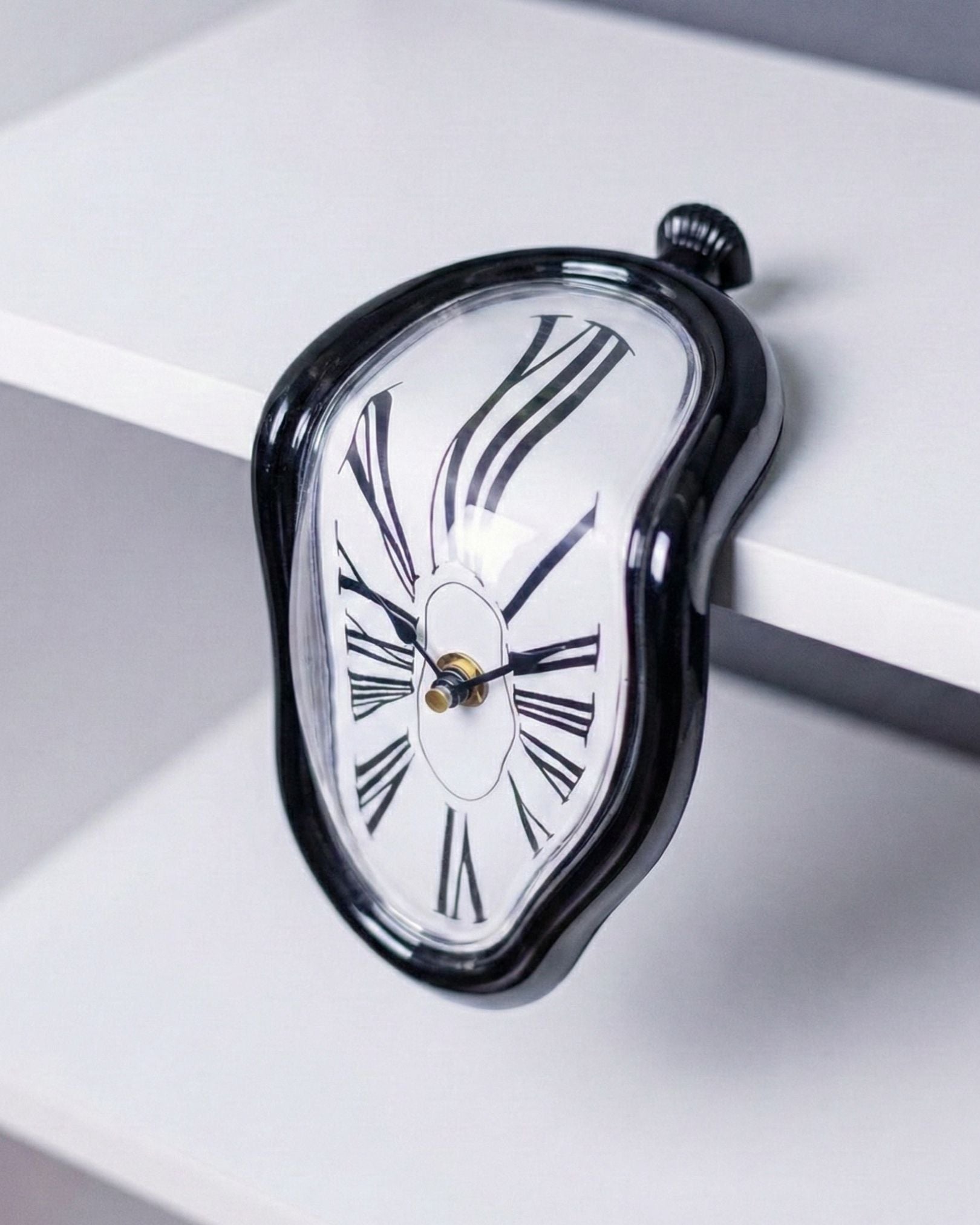 Angled view of Matte Black Melting Clock curved shape for modern desk decor