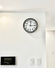 Close-up view emphasizing the dense, hand-drawn style black doodle pattern against the white background of the clock face.